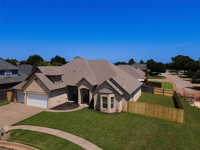 french country home featuring brick siding, driveway, an attached garage, and a shingled roof