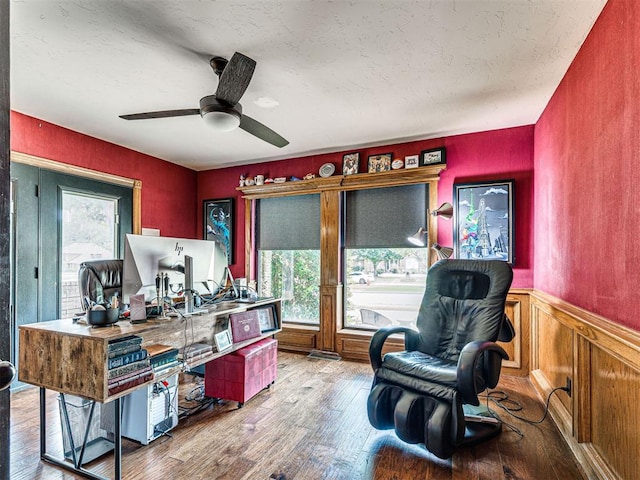 1521 Spring Creek Dr, Yukon, OK 73099 - home office with wood finished floors, a ceiling fan, a wainscoted wall, and a textured ceiling