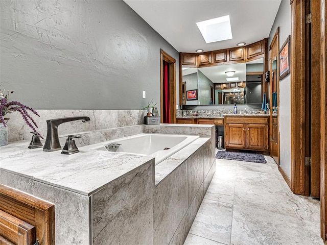 1521 Spring Creek Dr, Yukon, OK 73099 - bathroom with a skylight, vanity, a garden tub, and stone finish flooring