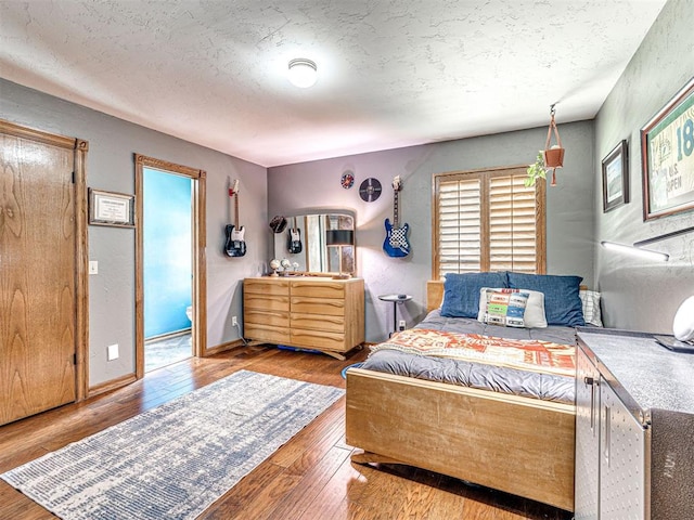 1521 Spring Creek Dr, Yukon, OK 73099 - bedroom featuring wood-type flooring and a textured ceiling