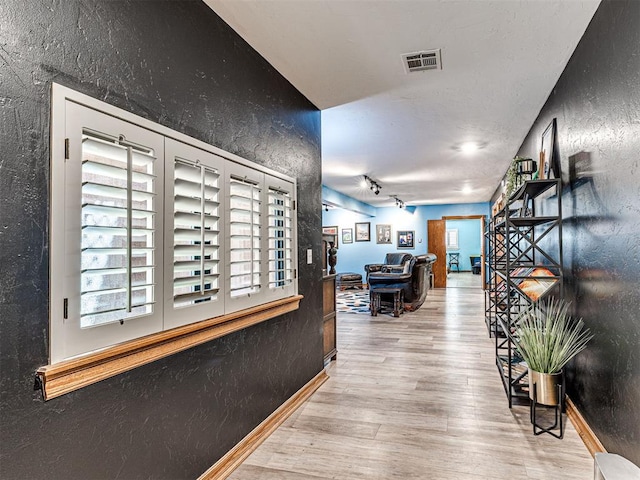 1521 Spring Creek Dr, Yukon, OK 73099 - hall with a textured wall, wood finished floors, and rail lighting