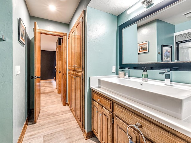 1521 Spring Creek Dr, Yukon, OK 73099 - bathroom featuring a textured wall, wood finished floors, and vanity