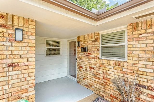 27 NE 65th St, Oklahoma City, OK 73105 - view of exterior entry featuring a porch and brick siding
