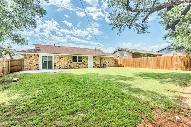 27 NE 65th St, Oklahoma City, OK 73105 - back of property featuring a patio area, a fenced backyard, and brick siding