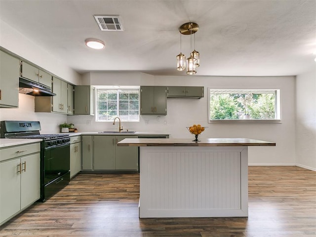 111 S Bristow Ave, Moore, OK 73160 - kitchen with black range with gas stovetop, green cabinetry, under cabinet range hood, and dark wood-style floors