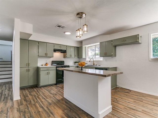 111 S Bristow Ave, Moore, OK 73160 - kitchen with black stove, green cabinetry, under cabinet range hood, and dark wood-type flooring