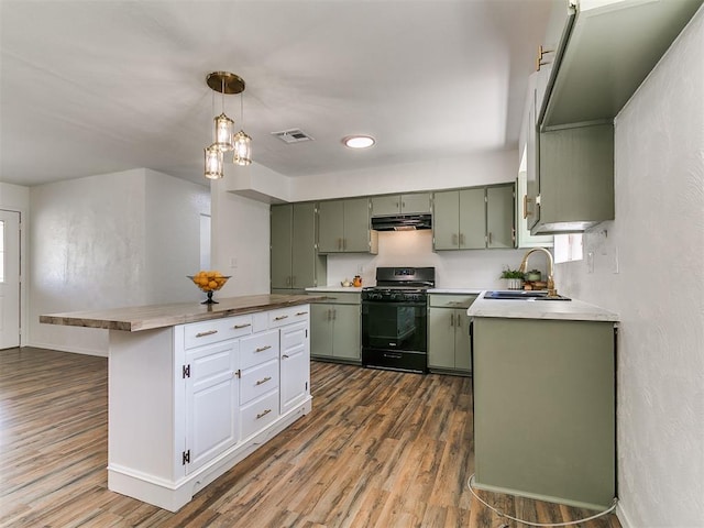 111 S Bristow Ave, Moore, OK 73160 - kitchen with black gas range, green cabinetry, dark wood-style floors, under cabinet range hood, and light countertops