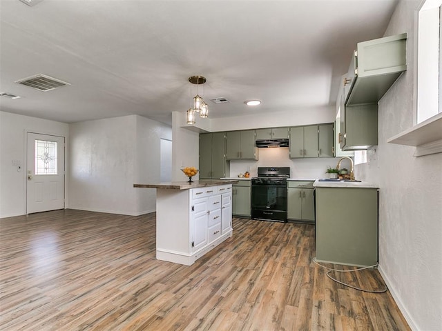111 S Bristow Ave, Moore, OK 73160 - kitchen featuring black range with gas stovetop, green cabinets, under cabinet range hood, and wood finished floors