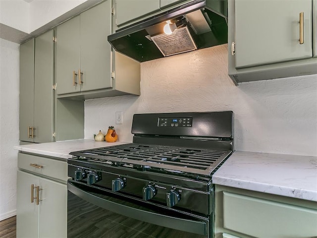 111 S Bristow Ave, Moore, OK 73160 - kitchen with black gas range oven, extractor fan, dark wood finished floors, light stone countertops, and gray cabinetry