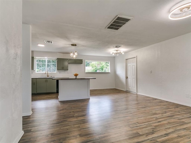 111 S Bristow Ave, Moore, OK 73160 - kitchen featuring a chandelier, dark wood finished floors, dark countertops, and a kitchen island