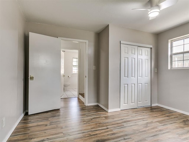 111 S Bristow Ave, Moore, OK 73160 - unfurnished bedroom with wood finished floors, multiple windows, and a closet