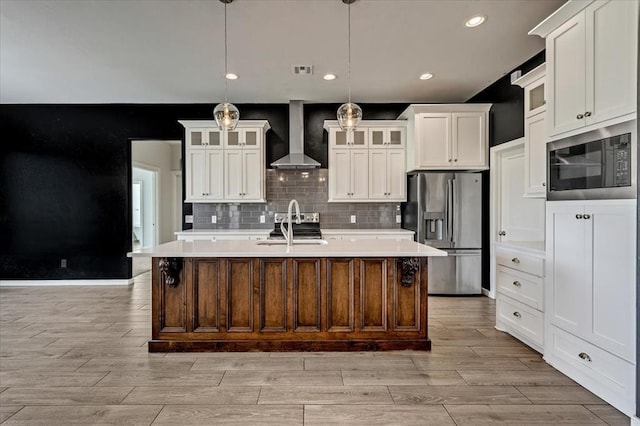 1069 Rheagen Kay Ave, Tuttle, OK 73089 - kitchen with appliances with stainless steel finishes, wall chimney range hood, light wood-type flooring, light countertops, and recessed lighting