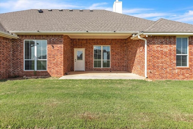 1069 Rheagen Kay Ave, Tuttle, OK 73089 - rear view of house with brick siding, a chimney, a shingled roof, a patio, and a lawn
