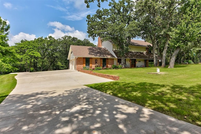 12629 Teakwood Rd, Oklahoma City, OK 73013 - view of front of property with brick siding, concrete driveway, a front lawn, a chimney, and a garage