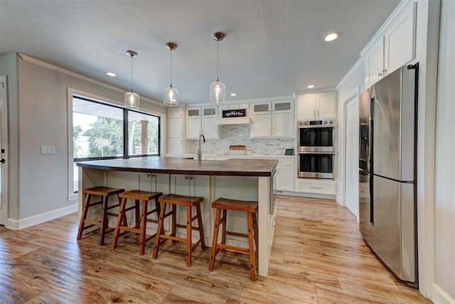 12629 Teakwood Rd, Oklahoma City, OK 73013 - kitchen featuring appliances with stainless steel finishes, wooden counters, white cabinets, tasteful backsplash, and recessed lighting