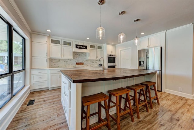 12629 Teakwood Rd, Oklahoma City, OK 73013 - kitchen with stainless steel appliances, butcher block counters, light wood-type flooring, backsplash, and recessed lighting