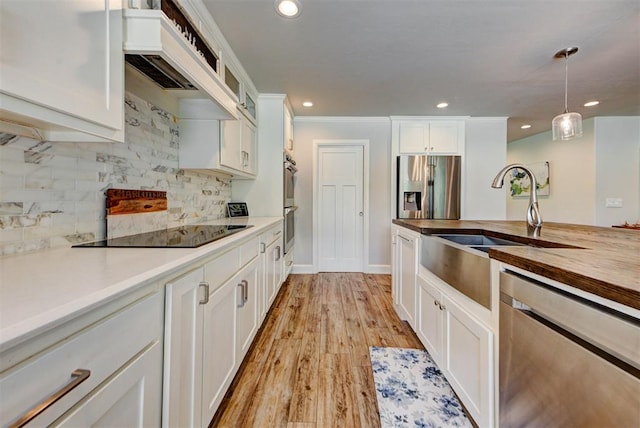 12629 Teakwood Rd, Oklahoma City, OK 73013 - kitchen featuring stainless steel appliances, premium range hood, wooden counters, white cabinetry, and hanging light fixtures