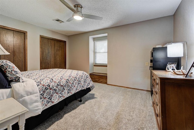 12629 Teakwood Rd, Oklahoma City, OK 73013 - bedroom with carpet floors, multiple closets, a ceiling fan, and a textured ceiling