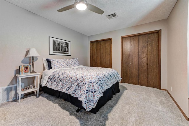 12629 Teakwood Rd, Oklahoma City, OK 73013 - carpeted bedroom featuring multiple closets, a textured ceiling, and a ceiling fan
