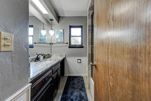 12629 Teakwood Rd, Oklahoma City, OK 73013 - full bathroom with vanity, wainscoting, a textured ceiling, and shower / bath combination