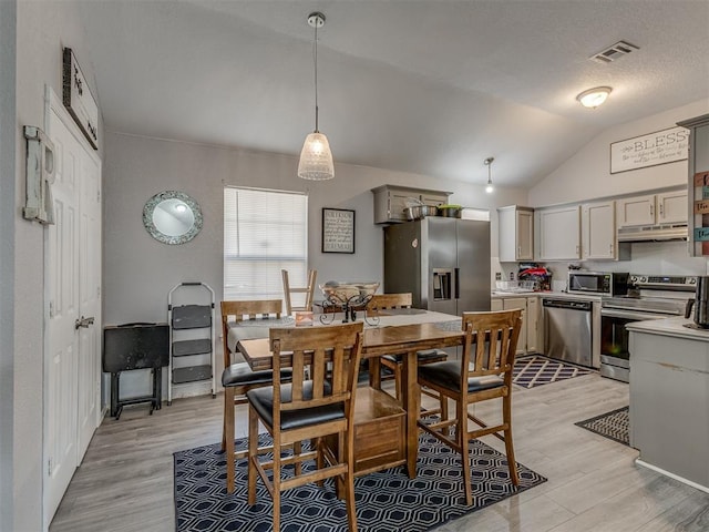 629 NW 121st St, Oklahoma City, OK 73114 - dining area featuring light wood-style flooring and vaulted ceiling