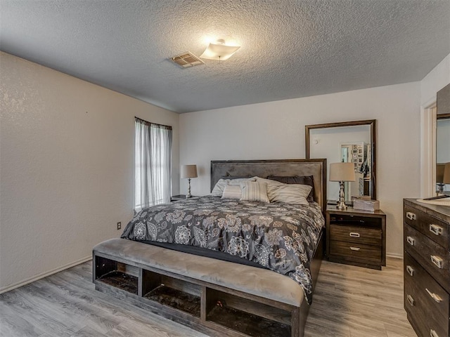 629 NW 121st St, Oklahoma City, OK 73114 - bedroom featuring light wood-style flooring and a textured ceiling