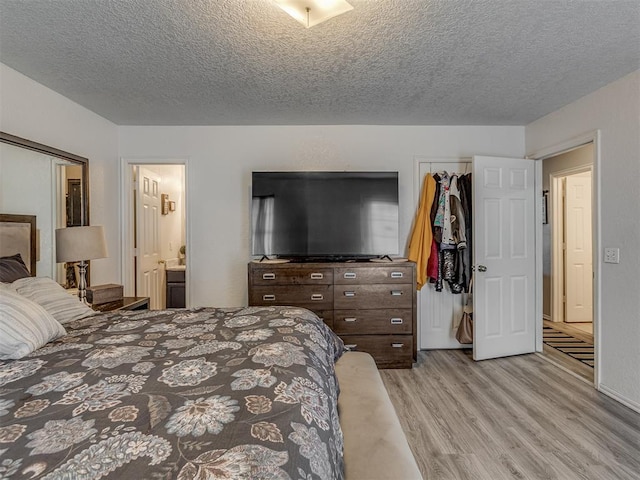 629 NW 121st St, Oklahoma City, OK 73114 - bedroom featuring light wood-style flooring, a textured ceiling, and ensuite bathroom