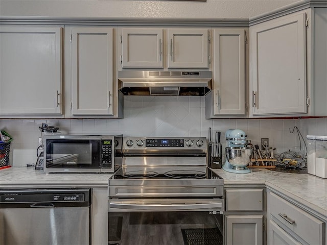 629 NW 121st St, Oklahoma City, OK 73114 - kitchen featuring stainless steel appliances, under cabinet range hood, light countertops, and backsplash