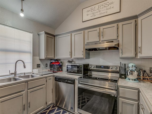 629 NW 121st St, Oklahoma City, OK 73114 - kitchen with stainless steel appliances, under cabinet range hood, vaulted ceiling, light countertops, and backsplash
