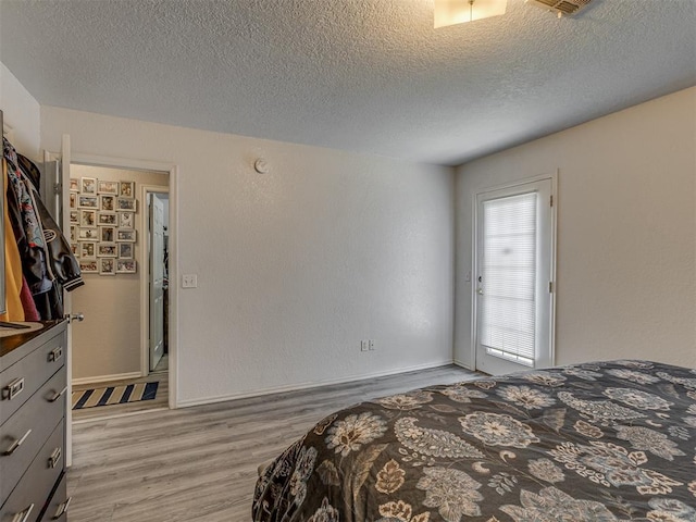 629 NW 121st St, Oklahoma City, OK 73114 - bedroom featuring light wood-type flooring and a textured ceiling