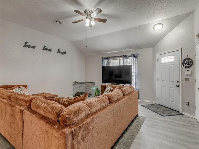 629 NW 121st St, Oklahoma City, OK 73114 - living room with vaulted ceiling, light wood-style floors, a ceiling fan, and a textured ceiling
