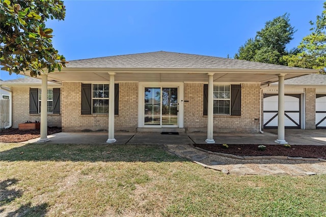 10516 NW 16th St, Yukon, OK 73099 - view of front of home with a front yard, a garage, covered porch, and brick siding