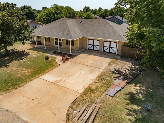 10516 NW 16th St, Yukon, OK 73099 - view of front of property with an attached garage, brick siding, driveway, roof with shingles, and a porch