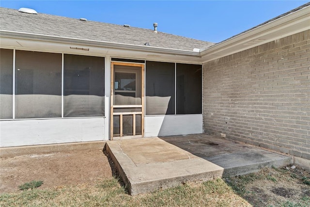 10516 NW 16th St, Yukon, OK 73099 - property entrance with brick siding, roof with shingles, and a patio area
