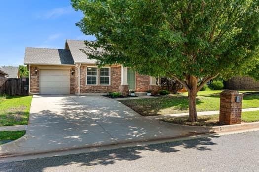 2709 NW 184th St, Edmond, OK 73012 - view of front facade with a garage, driveway, brick siding, and a front lawn