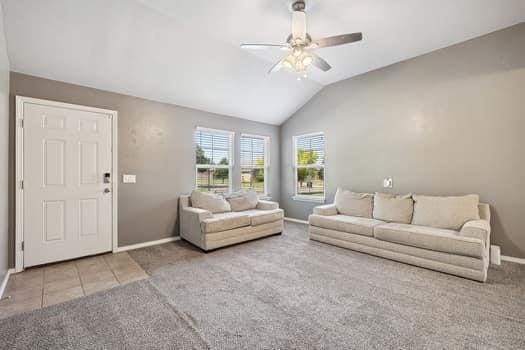 2709 NW 184th St, Edmond, OK 73012 - living area with carpet flooring, ceiling fan, vaulted ceiling, and tile patterned floors