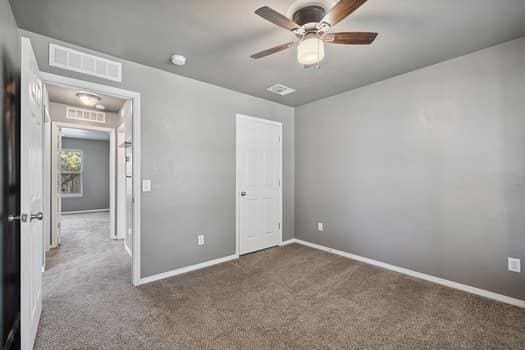 2709 NW 184th St, Edmond, OK 73012 - unfurnished bedroom with carpet floors and a ceiling fan