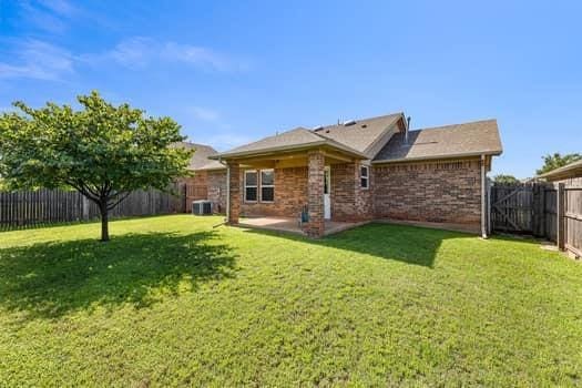 2709 NW 184th St, Edmond, OK 73012 - back of house featuring a fenced backyard, a patio, and brick siding
