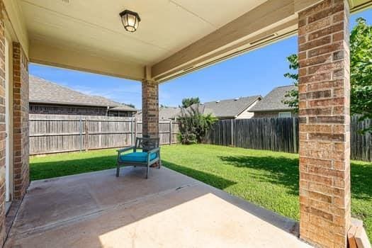 2709 NW 184th St, Edmond, OK 73012 - fenced backyard with a patio area
