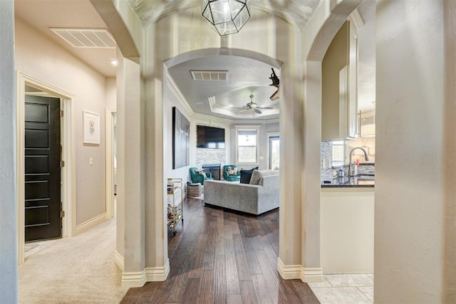 3937 NW 167th Ter, Edmond, OK 73012 - corridor with arched walkways, ornamental molding, wood finished floors, and a raised ceiling