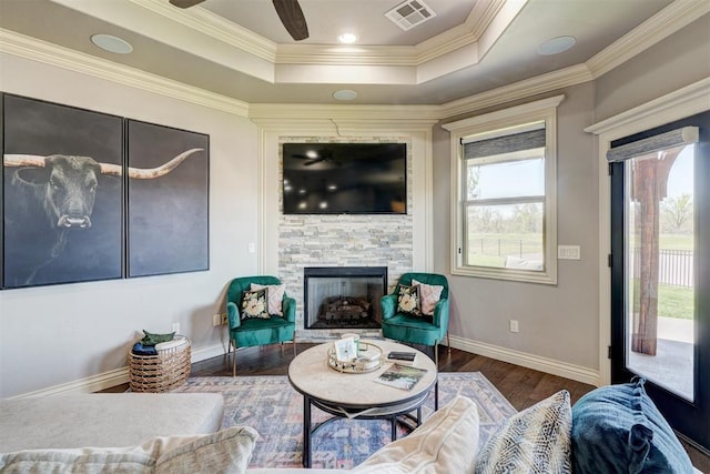 3937 NW 167th Ter, Edmond, OK 73012 - living area with healthy amount of natural light, wood finished floors, a raised ceiling, a stone fireplace, and ornamental molding