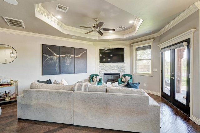 3937 NW 167th Ter, Edmond, OK 73012 - living room featuring a glass covered fireplace, a ceiling fan, ornamental molding, dark wood-type flooring, and a raised ceiling