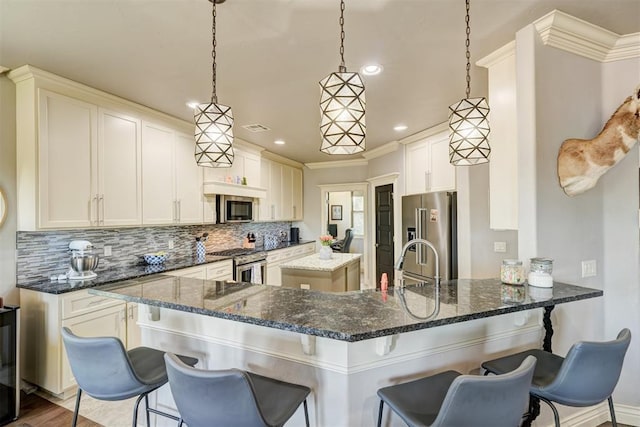 3937 NW 167th Ter, Edmond, OK 73012 - kitchen featuring high end appliances, backsplash, recessed lighting, dark stone counters, and a peninsula