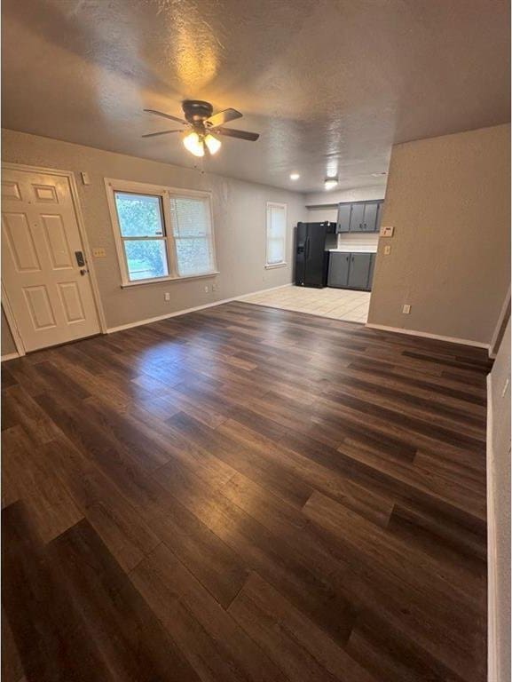 1412 NW 96th St, Oklahoma City, OK 73114 - unfurnished living room featuring a ceiling fan, dark wood-style floors, and a textured ceiling