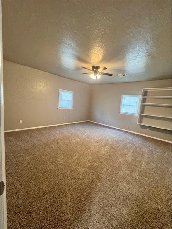 1412 NW 96th St, Oklahoma City, OK 73114 - carpeted spare room featuring a textured ceiling, ceiling fan, and plenty of natural light