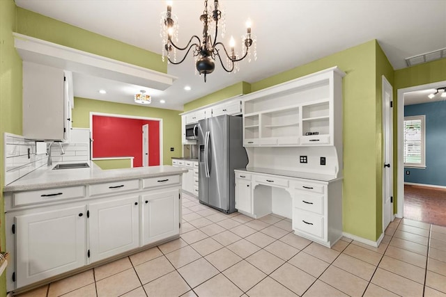 2805 Tudor Rd, Oklahoma City, OK 73127 - kitchen with appliances with stainless steel finishes, open shelves, a chandelier, light tile patterned floors, and white cabinets