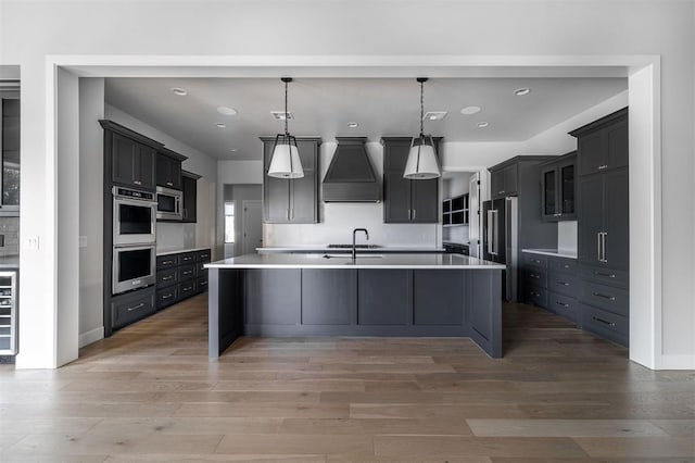 4716 Moulin Rd, Edmond, OK 73034 - kitchen with premium range hood, stainless steel appliances, light wood-style flooring, light countertops, and recessed lighting