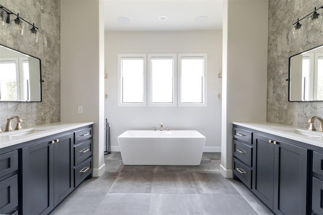 4716 Moulin Rd, Edmond, OK 73034 - bathroom featuring healthy amount of natural light, two vanities, a soaking tub, and tasteful backsplash