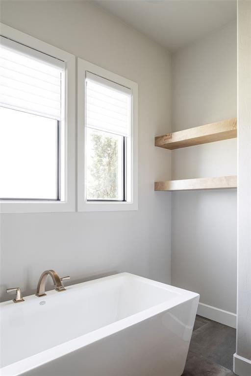 4716 Moulin Rd, Edmond, OK 73034 - bathroom featuring a freestanding tub and baseboards