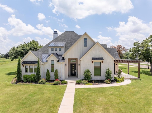 4716 Moulin Rd, Edmond, OK 73034 - modern farmhouse style home featuring a standing seam roof, a front yard, brick siding, and board and batten siding